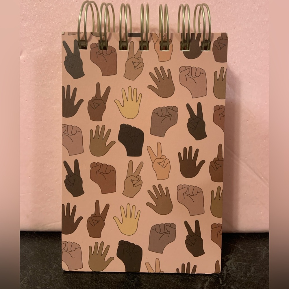 6 1/2“ x 4“ lined notebook with all different hands on the front